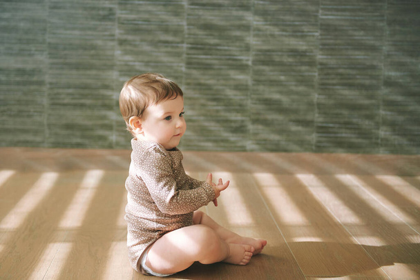  Portré imádnivaló baba ül a padlón a nappaliban - Fotó, kép