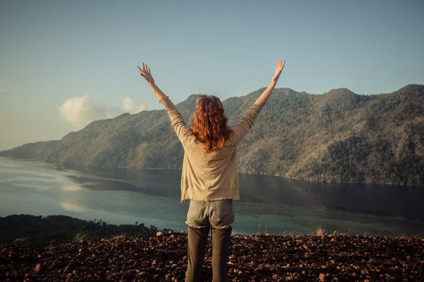 Woman raising her arms on top of mountain - Photo, Image