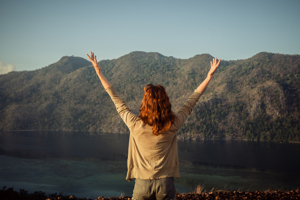 Mujer levantando los brazos en la cima de la montaña
 - Foto, Imagen