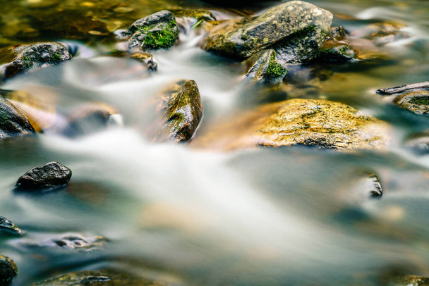 Immagine a lunga esposizione di acqua che scorre intorno alle rocce in un torrente nella Carolina del Nord - Foto, immagini
