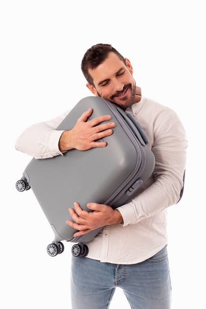 Bearded man hugging his travel suitcase. Traveling brings happiness. Travel safety. Hand luggage. Measurements allowed by airlines in suitcases - Photo, Image