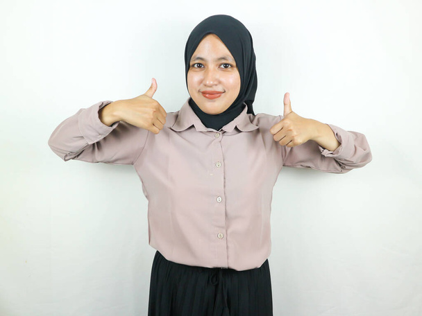 Smiling asian muslim woman in hijab showing thumb up in approval, recommending, like something good - Photo, Image