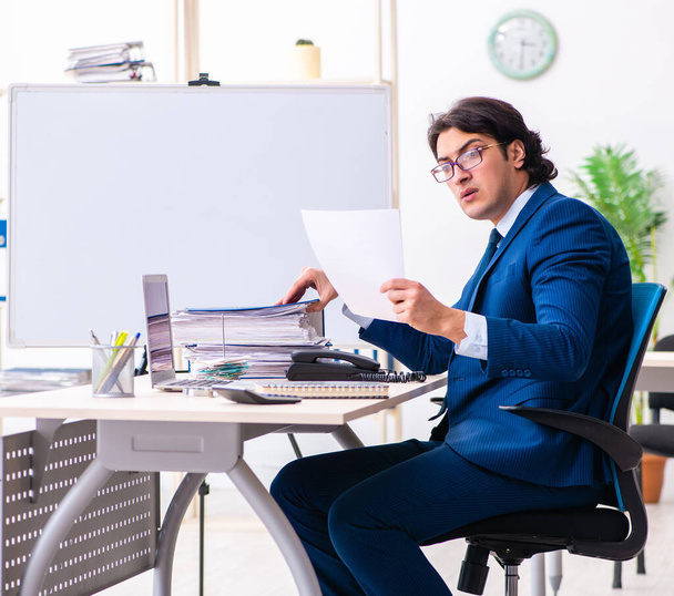 Молодий бізнесмен сидить і працює в офісі
 - Фото, зображення