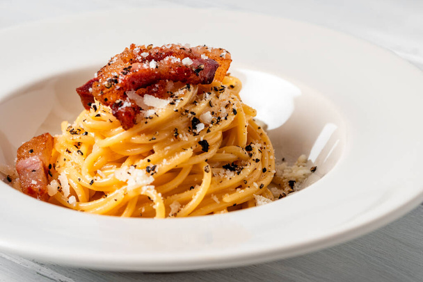Délicieux spaghetti alla carbonara, une recette romaine traditionnelle de pâtes garnie d'oeuf, pecorino et sauce au poivre noir, nourriture italienne - Photo, image