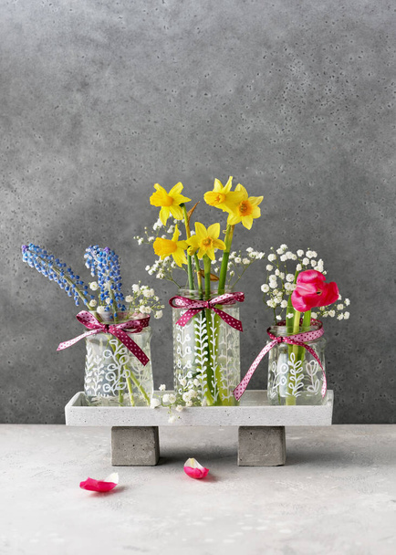 Drei handbemalte Glasvasen mit verschiedenen Pflanzenmotiven und schönen Blumensträußen darin. Malen auf Glasgefäßen, Kreativität mit den eigenen Händen. Hobby für Kinder. Kopierraum. - Foto, Bild