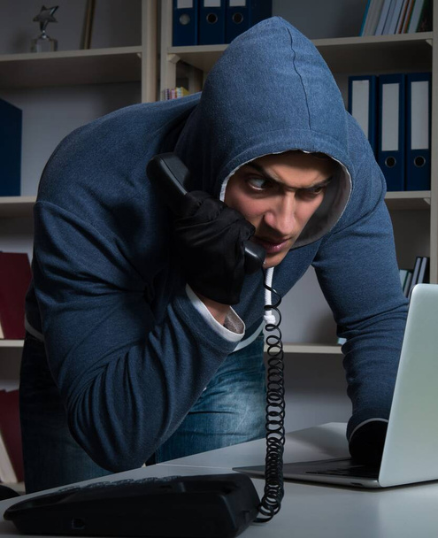 Молодой хакер взламывает компьютер ночью - Фото, изображение
