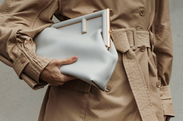 Modedetails. Een gast draagt een beige trench jas, Fendi tas, buiten Sportmax show tijdens Milan Fashion Week Womenswear Spring / Summer 2024. - Foto, afbeelding