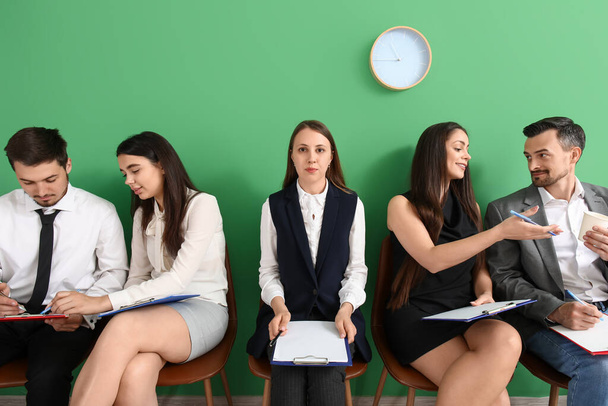 Jóvenes solicitantes con portapapeles esperando entrevista de trabajo en la habitación - Foto, Imagen