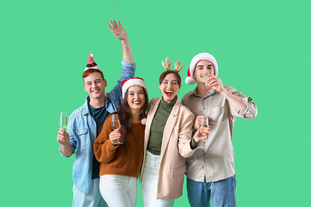 Yeşil arka planda şampanya içen bir grup arkadaş. Yeni yıl kutlaması - Fotoğraf, Görsel