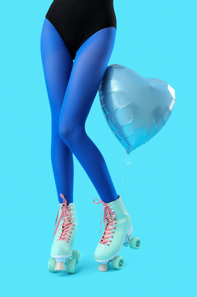 Palloncino e gambe di donna in pattini a rotelle su sfondo blu - Foto, immagini