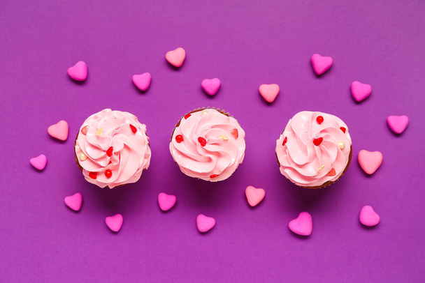 Smaczne babeczki z sercami na Walentynki na fioletowym tle - Zdjęcie, obraz