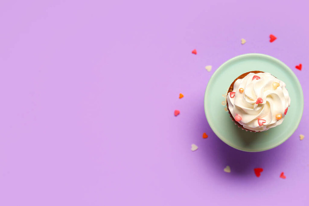Stand met lekkere cupcake voor Valentijnsdag op paarse achtergrond - Foto, afbeelding