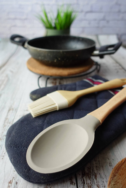  tenedor de cubiertos de madera y cuchara y sartén de cocina en la mesa . - Foto, Imagen
