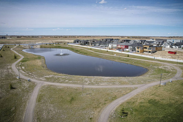 Imagen del dron capturando la ciudad de Warman en Saskatchewan durante la temporada de verano, destacando sus áreas suburbanas y residenciales rodeadas de exuberante vegetación y vibrante atmósfera - Foto, Imagen