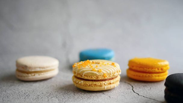 Luxe kleur macarons, Franse snack, banketbakkersrecept, amandelmeel, kleurrijke macarons minimale samenstelling, trendy op grijze achtergrond, selectieve focus - Foto, afbeelding