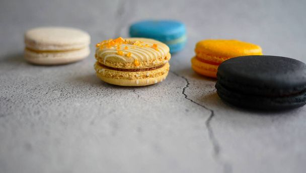 Fantasievolle Makronen, französischer Snack, Gebäck Rezept, Mandelmehl, bunte Macarons minimale Zusammensetzung, trendy auf grauem Hintergrund, selektiver Fokus - Foto, Bild