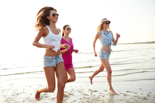 група усміхнених жінок, що біжать на пляжі
 - Фото, зображення