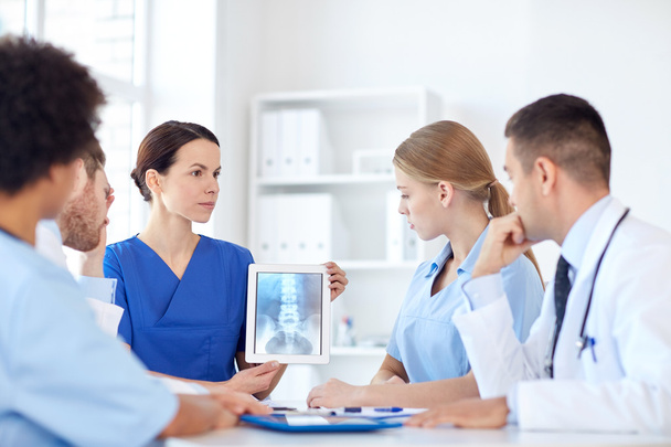 group of doctors with x-ray on tablet pc at clinic - Фото, изображение