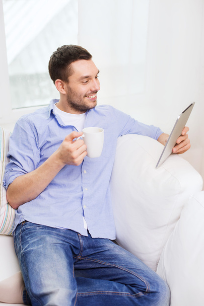 smiling man with tablet pc and cup at home - Foto, Imagem