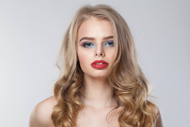 Pěkný zdravý blonďatý model pózující izolované na bílém pozadí. Žena s make-upem, svěží čistou pletí a vlnitými blond vlasy  - Fotografie, Obrázek