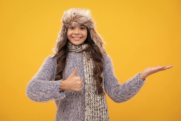 Winter hat. Cold season concept. Winter fashion accessory for children. Teen girl wearing warm knitted hat. Happy face, positive and smiling emotions of teenager girl - Foto, Imagem