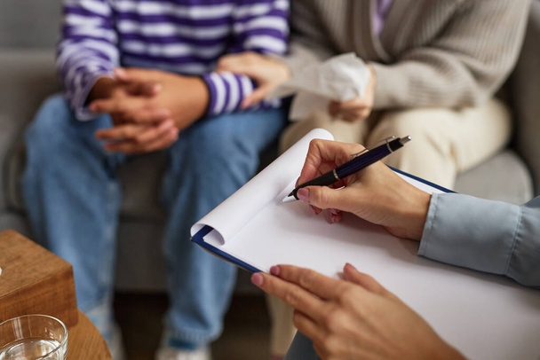 Kädet perhepsykologi tekee muistiinpanoja puhuessaan asiakkaille - Valokuva, kuva