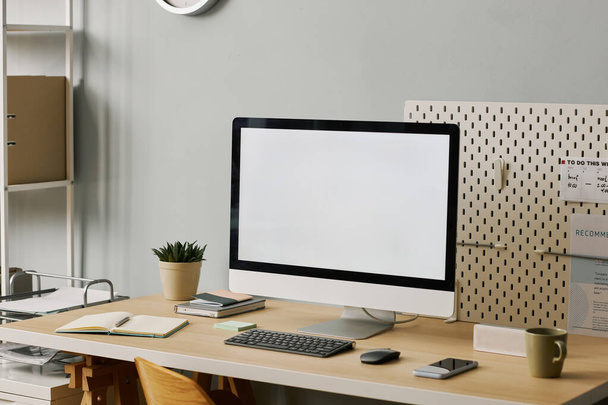 Background image of blank computer screen on minimal home office workplace set at angle, copy space - Photo, Image