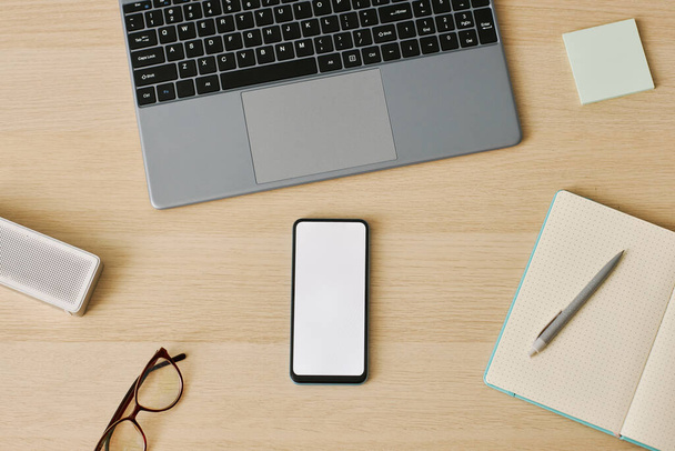 Vista superior mínima do smartphone com mockup de tela branca no local de trabalho da mesa, espaço de cópia - Foto, Imagem