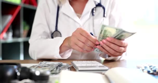 Arzt betrachtet Dollars als Bestechung und Verbrechen. Berechnet Kosten für die Untersuchung im Krankenhaus spart Geld für medizinische Leistungen und Versicherungen - Filmmaterial, Video