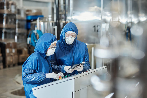 Retrato de dos trabajadores que usan equipo de protección en la fábrica industrial - Foto, imagen