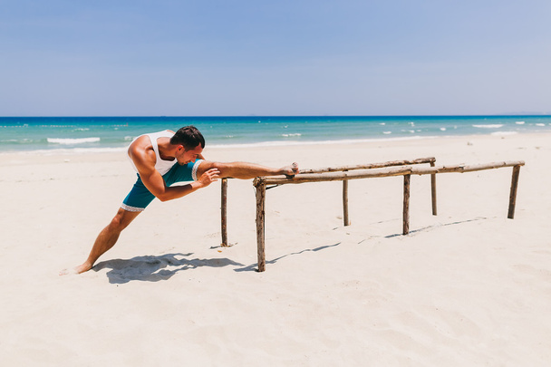 mężczyzna w stretching na plaży - Zdjęcie, obraz