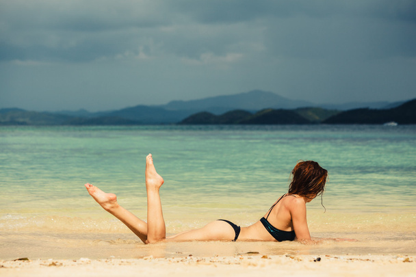 Сексуальна молода жінка лежить на пляжі
 - Фото, зображення