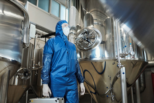 Retrato de bajo ángulo del trabajador que usa equipo de protección en taller de fábrica química, espacio de copia - Foto, imagen