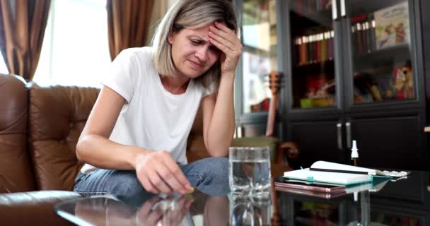 Egy pohár víz és egy fejfájásos nő tablettákat szed. Fájdalomcsillapítók fejfájásra és migrénre - Felvétel, videó