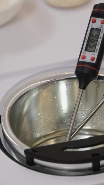 mesurer la température de la cire de noix de coco fondue dans un bain d'eau, faire des bougies. Images 4k de haute qualité - Séquence, vidéo