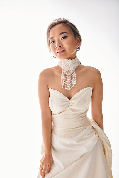 alluring asian young girl in luxury dress with sophistication necklace posing to camera - Photo, Image