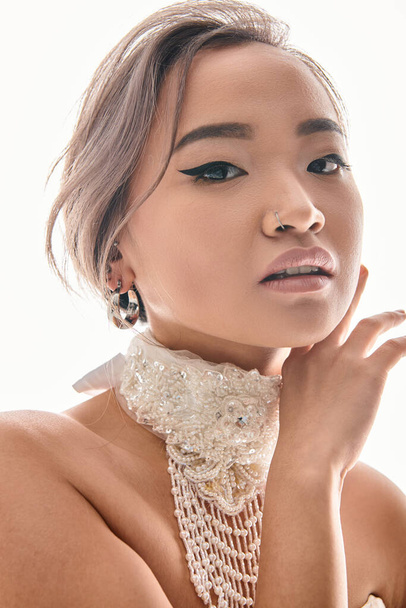 close up of grace asian bride with luxury necklace framing with hands to face on white background - Zdjęcie, obraz