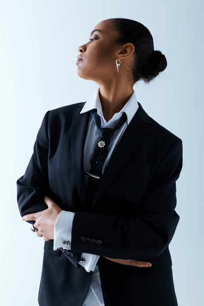 Itsevarma nuori afroamerikkalainen nainen, parikymppinen, seisoo kädet ristissä puvussa ja solmiossa. - Valokuva, kuva