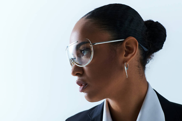 Μια νεαρή Αφροαμερικανή γύρω στα 20, με γυαλιά και λευκό πουκάμισο. - Φωτογραφία, εικόνα