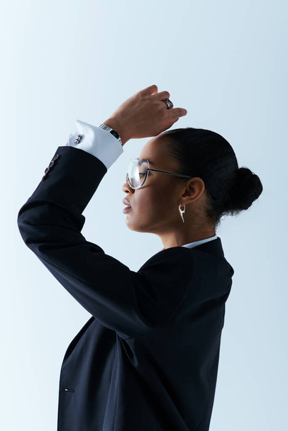 Una giovane donna afroamericana sulla ventina indossa una giacca nera e occhiali da sole - Foto, immagini