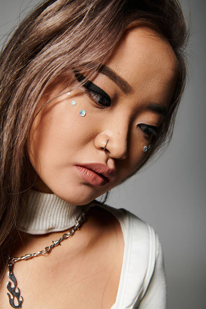 close up of lovely asian girl in her 20s with heavy makeup leaning head and looking down - Foto, Imagem