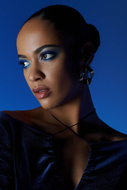 Νεαρή Αφρο-Αμερικανίδα με μαύρο φόρεμα με τσάντα, σαγηνευτικά μπλε μάτια. - Φωτογραφία, εικόνα