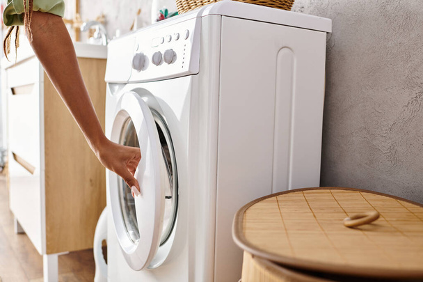 Africano mulher americana configurar máquina de lavar roupa em uma lavandaria limpa com pisos de azulejos e paredes brancas. - Foto, Imagem