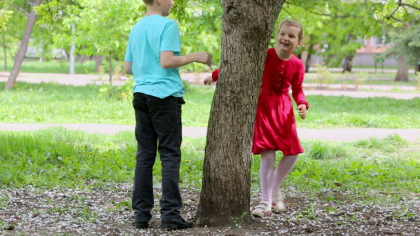 Chico y chica corren alrededor del árbol
 - Imágenes, Vídeo