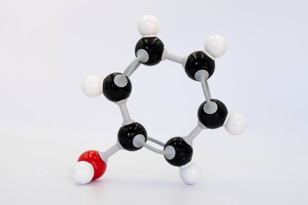 Cząsteczka fenolu (lub benzenolu) wytwarzana przez model molekularny na białym tle. Wzór chemiczny z kolorowymi atomami i wiązaniami - Zdjęcie, obraz