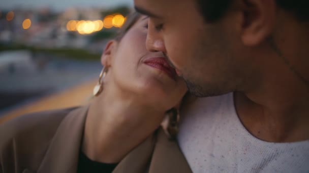 Closeup tender couple kiss lips hugging in evening lights. Loving smiling woman look partner talking on date outdoors. Man embracing girl expressing love care at night. Harmony romantic relationship - Footage, Video