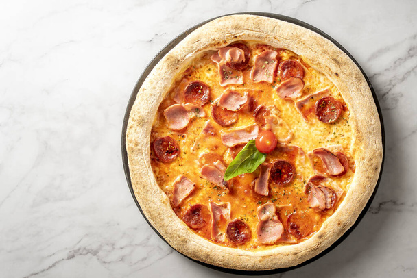 Włoska kiełbasa i pizza serowa serwowane na nieskazitelnym białym marmurowym stole. Doskonałość kulinarna. Wysokiej jakości zdjęcie - Zdjęcie, obraz