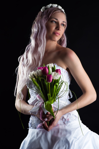 Beautiful woman with a bouquet of tulips - Фото, зображення