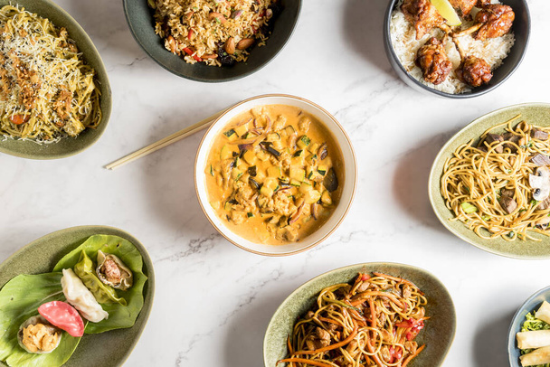 Masa bir dizi lezzetli Asya yemekleriyle dolup taşıyor. Asya mutfağının zengin ve çeşitli tatları. Yüksek kalite fotoğraf - Fotoğraf, Görsel