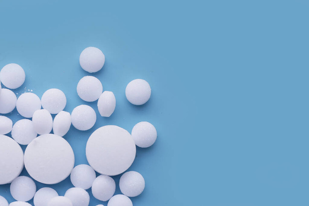 White mothballs on blue background. - Photo, Image